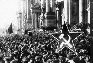 1918, Berlin, Germany --- A huge crowd turns out for a Communist rally in Berlin. One person holds a large star-shaped placard emblazoned with a hammer and sickle. 1918. --- Image by © Hulton-Deutsch Collection/CORBIS