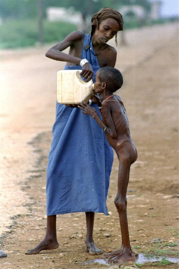 Μια γυναίκα δίνει λίγο νερό σε ένα παιδί σκελετωμένο από την ασιτία κοντά σε ένα στρατόπεδο προσφυγών στην Μπαϊντόα, Σομαλία, Δεκέμβριος 1992